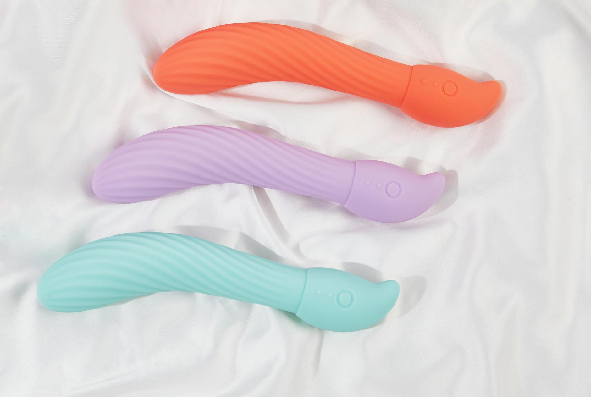 Woman holding colorful silicone vibrators, considering options for sensitive skin care