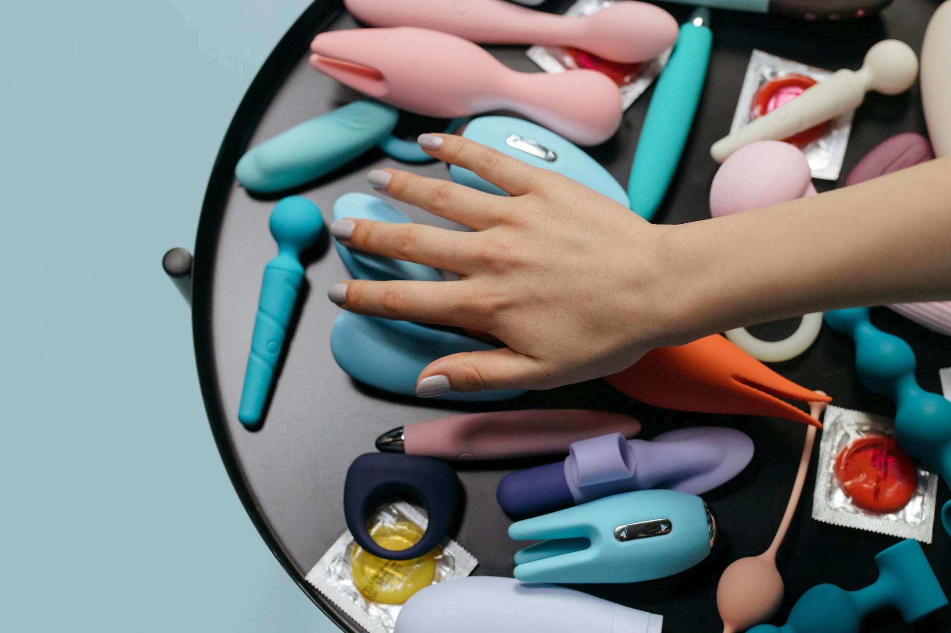 A collection of colorful sex toys arranged on a surface, showing variety in shapes and sizes