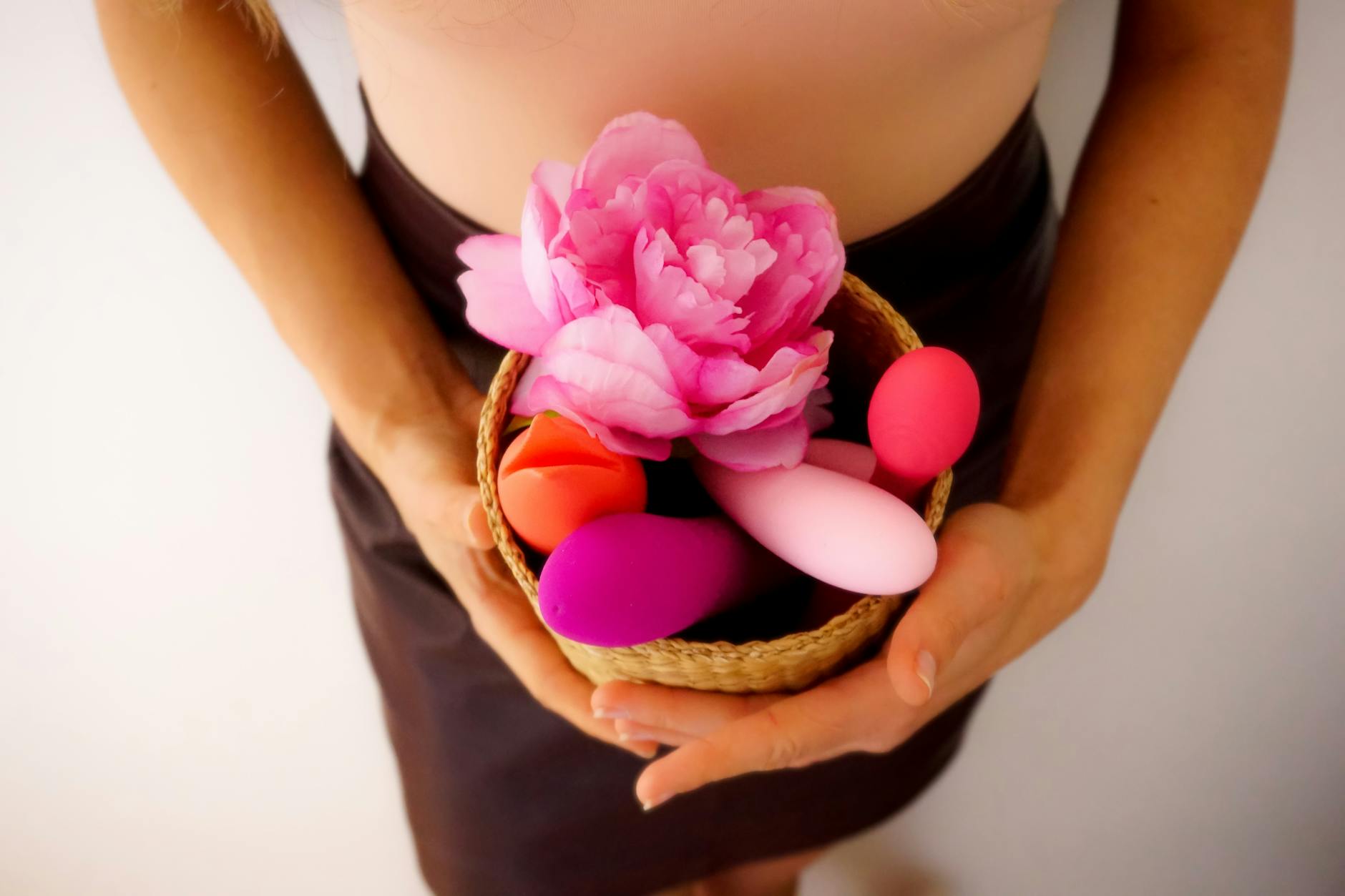 Colorful toys arranged in a basket with flowers, representing pleasure recovery and wellness