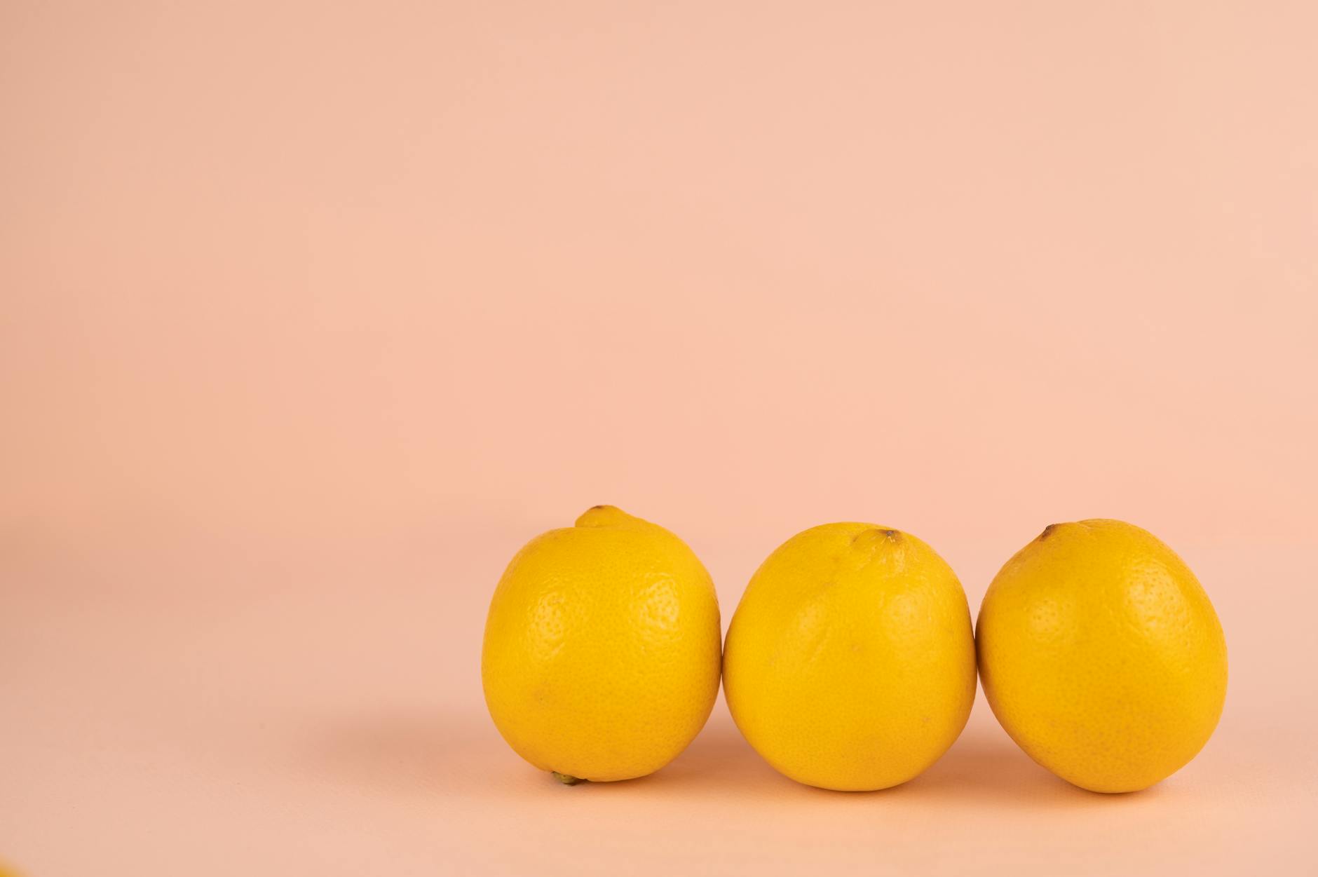 Bright ripe lemons arranged on a pastel background, representing slow, intentional pleasure